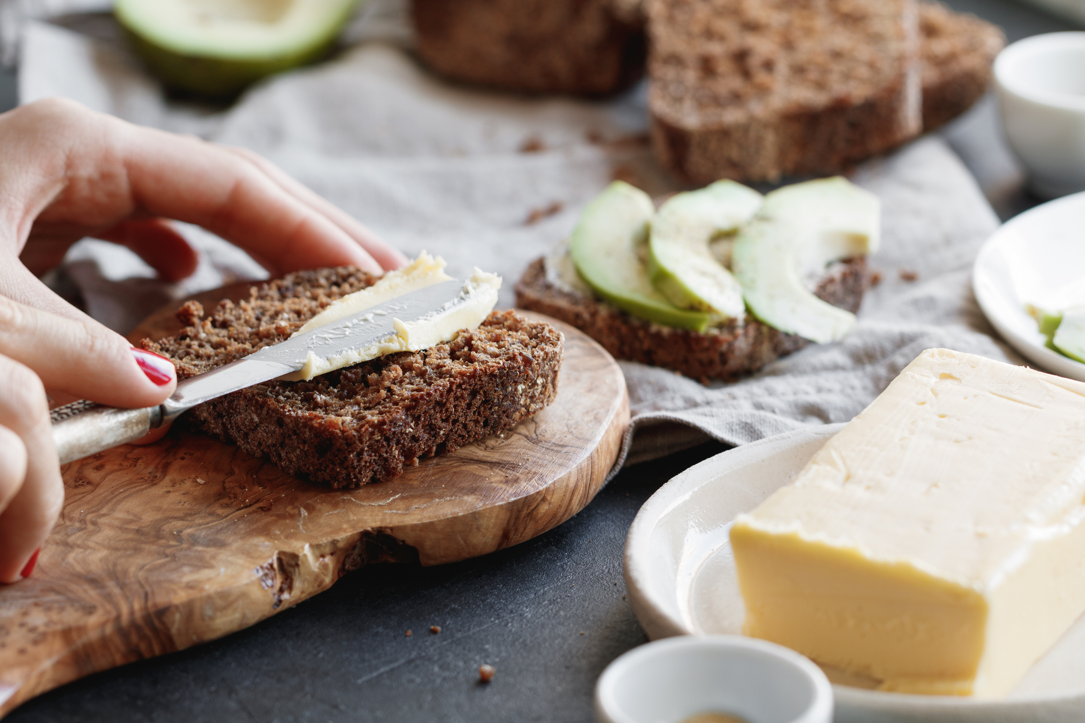 A slice of rye bread being buttered